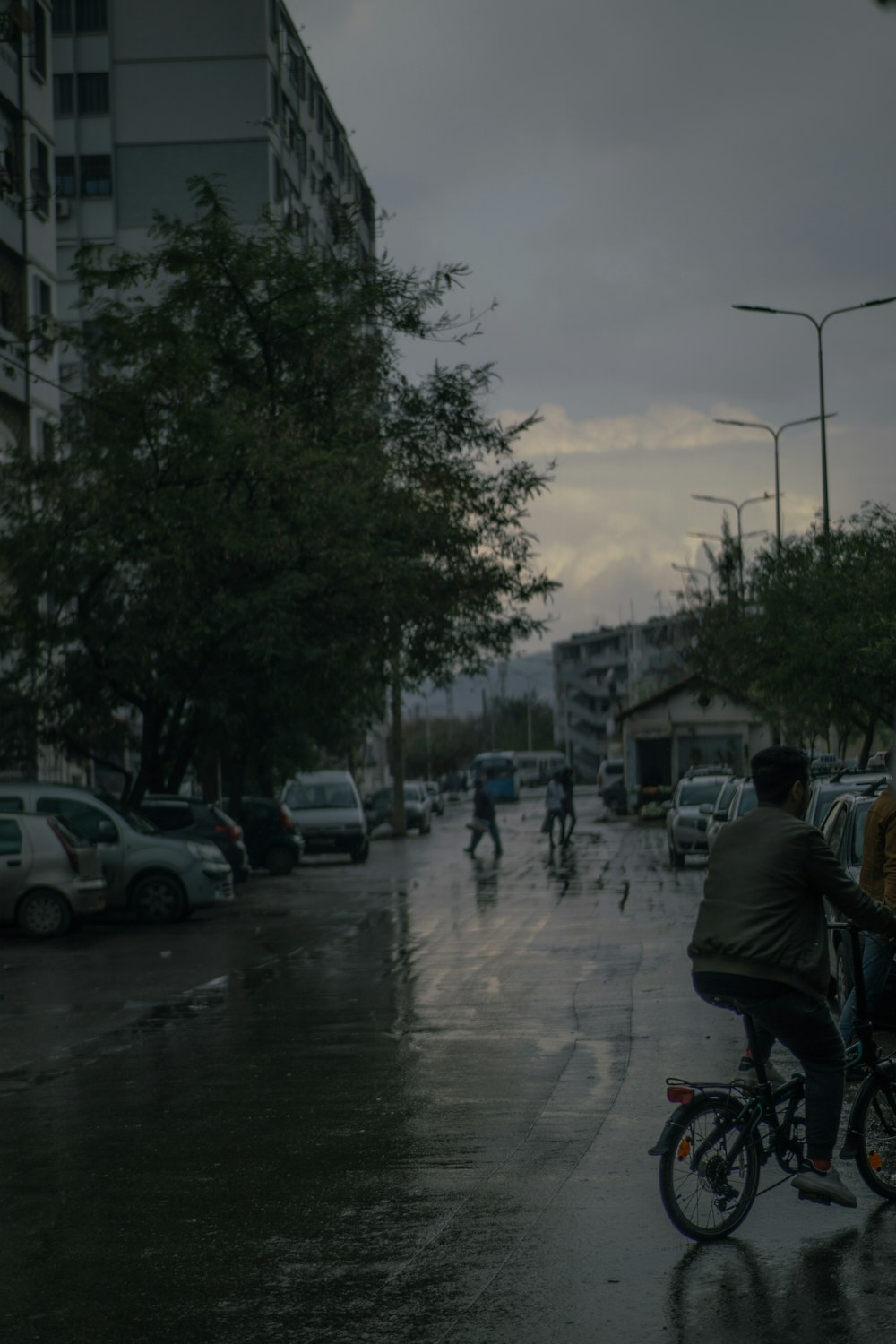 a man riding a bike down a rain soaked street