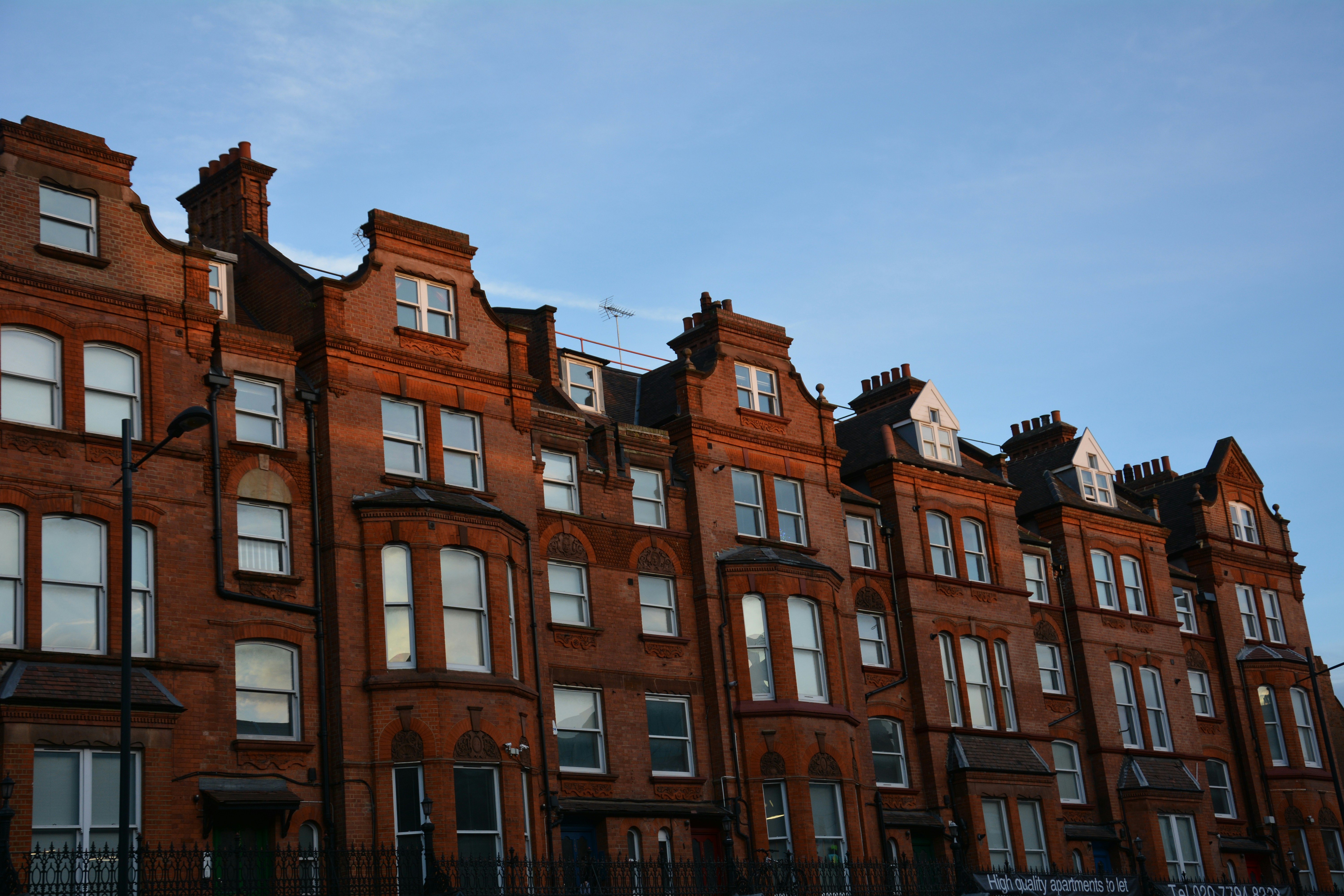 a row of brick buildings with a blue sky in the background
