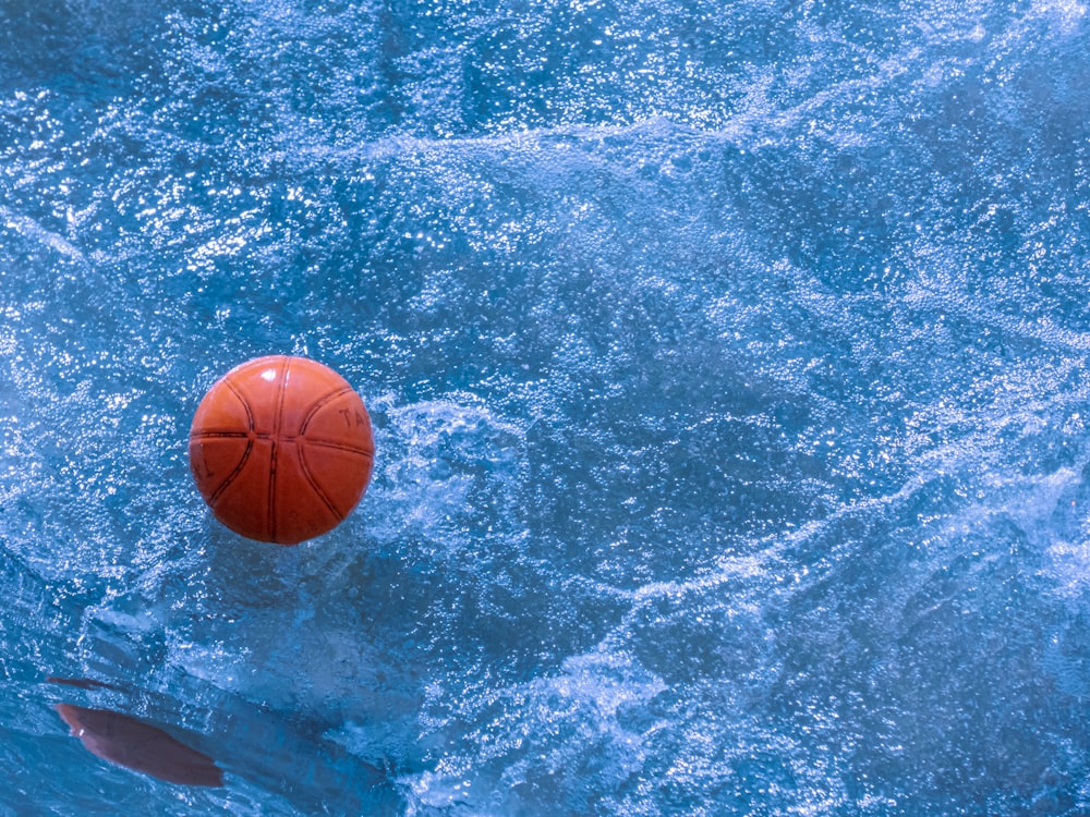 a basketball floating on top of a body of water