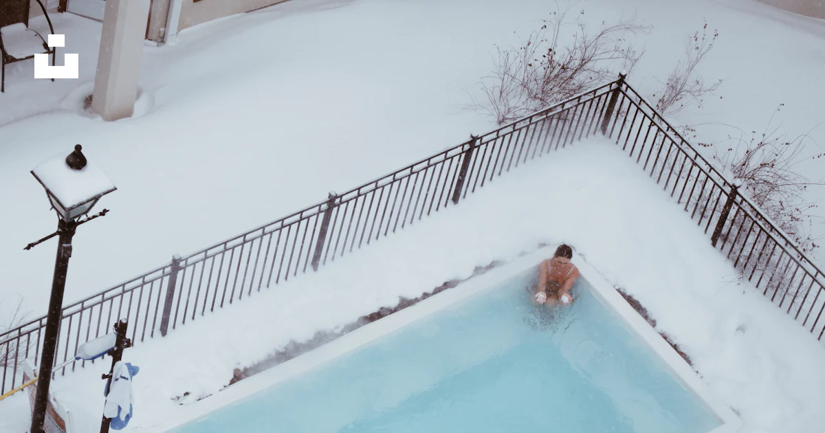 A couple of people in a swimming pool covered in snow photo – Free Mont ...