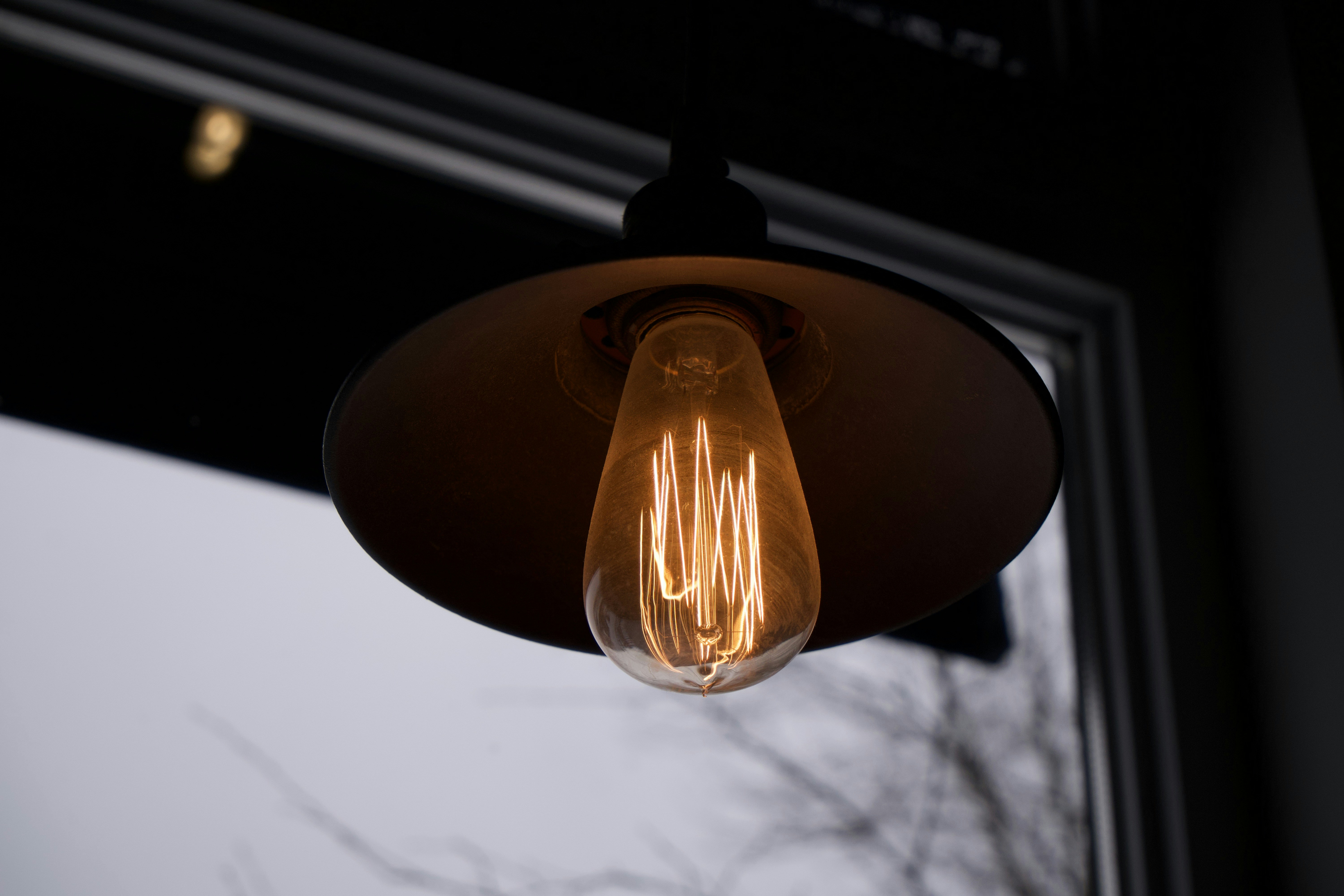 Warm coffee shop interior with hanging light bulb