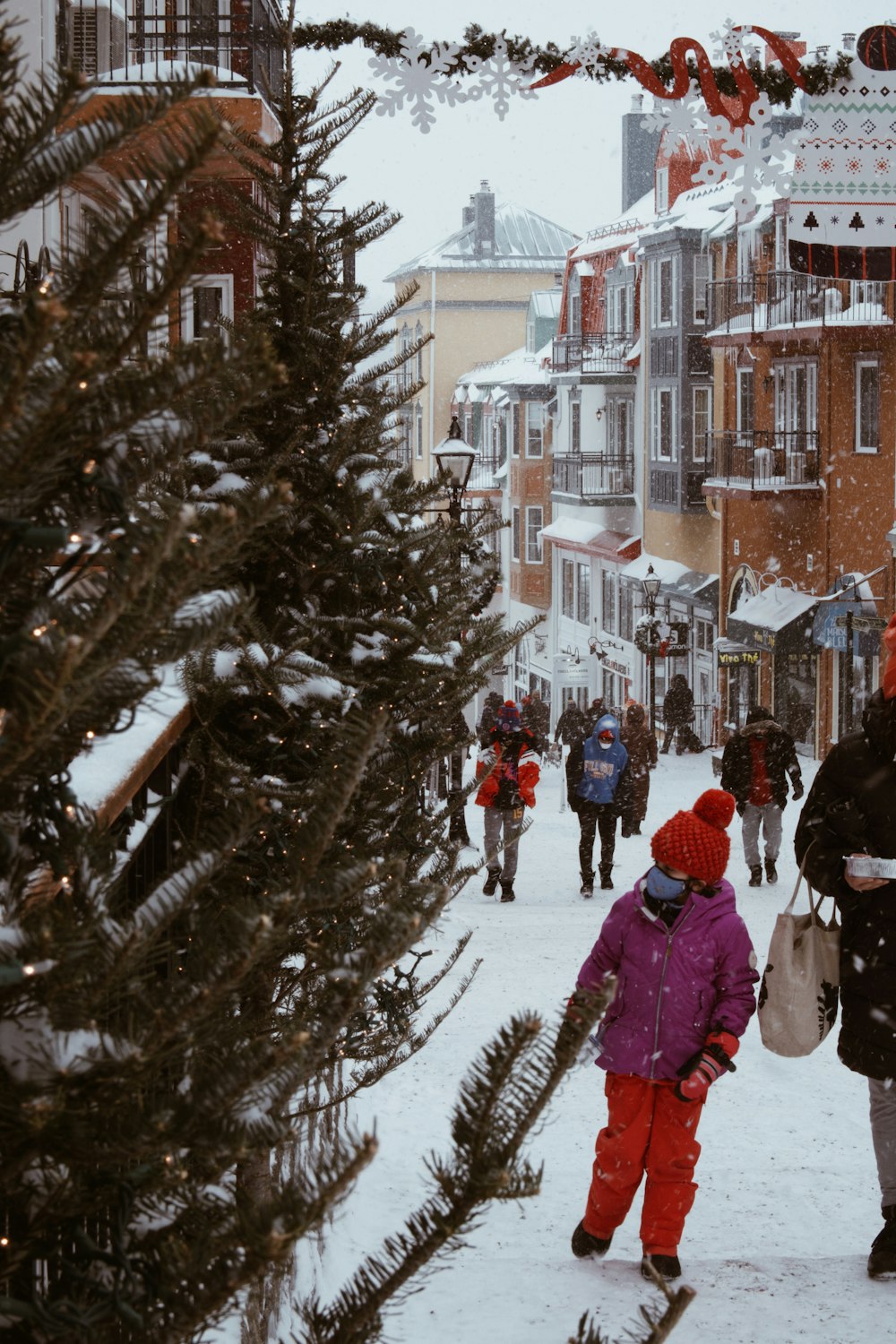 a group of people walking down a snow covered street