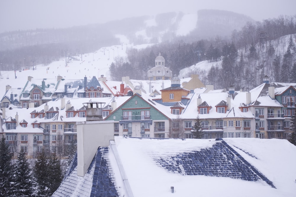 a view of a town in the mountains covered in snow