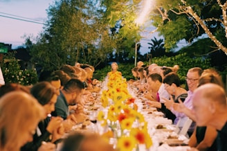 a group of people sitting at a long table