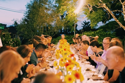 a group of people sitting at a long table
