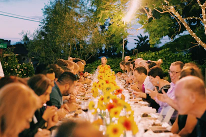 a group of people sitting at a long table