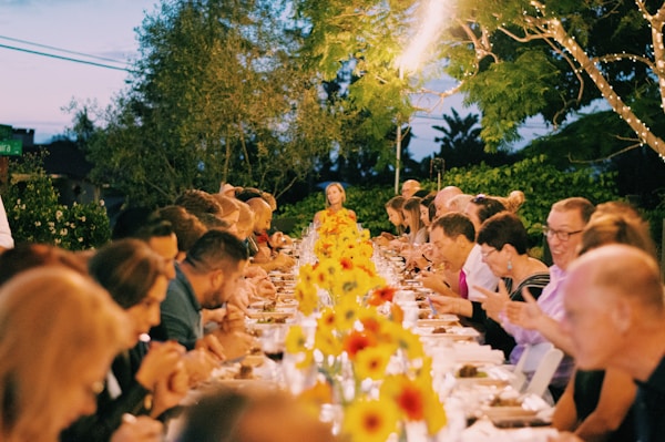 a group of people sitting at a long table