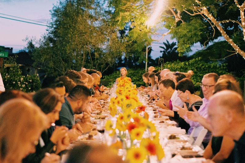 a group of people sitting at a long table