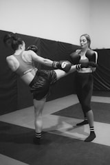 a couple of women standing next to each other in a gym