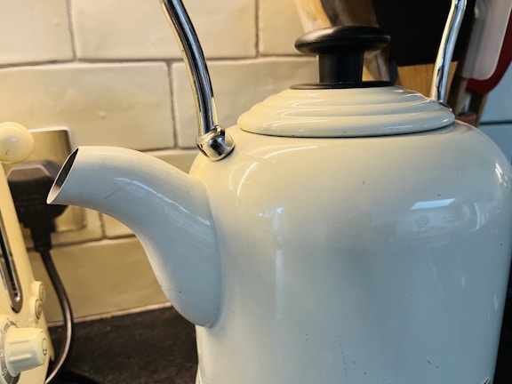Sleek black cordless kettle glowing softly on a dark kitchen counter