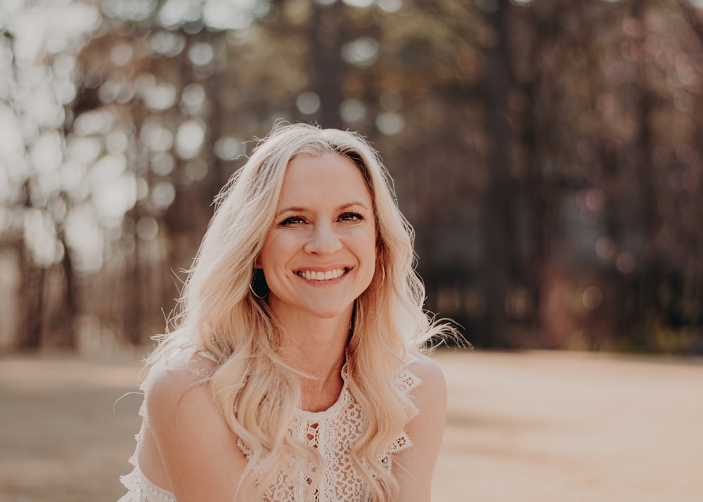 a woman with blonde hair is smiling for the camera