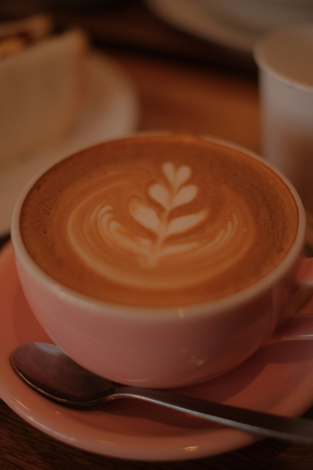 a cup of cappuccino on a saucer with a spoon