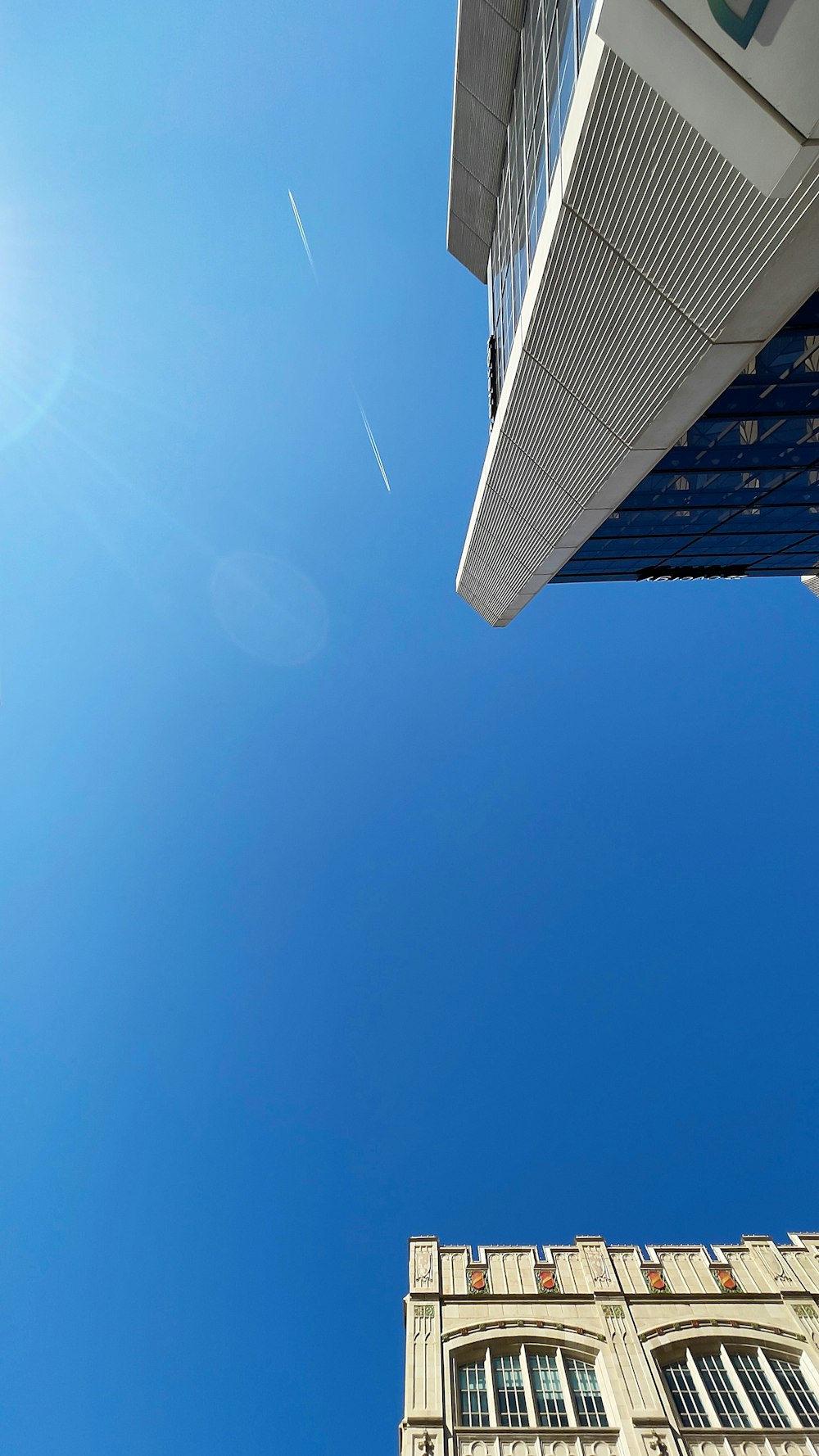 looking up at a tall building with a blue sky in the background