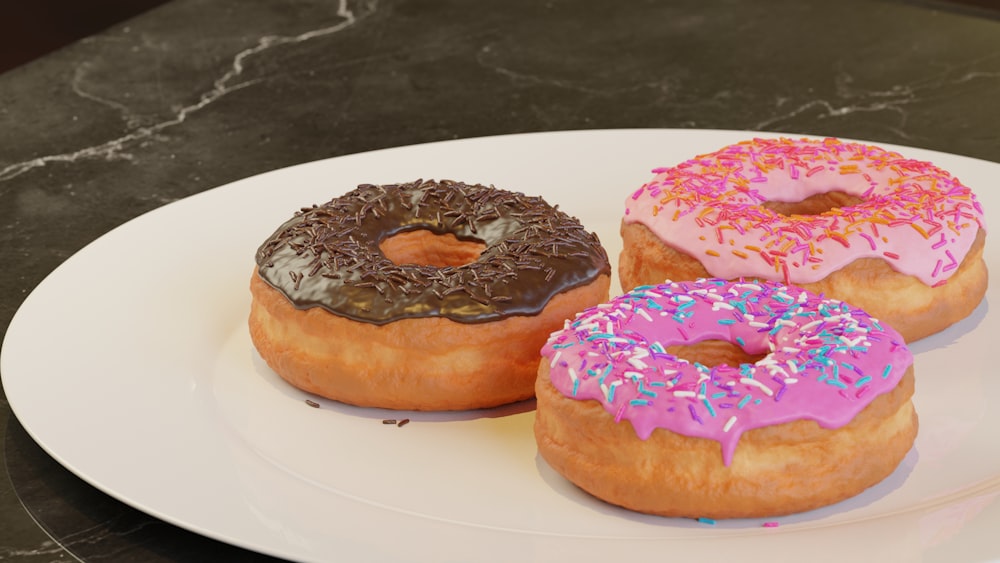 three donuts on a plate with sprinkles