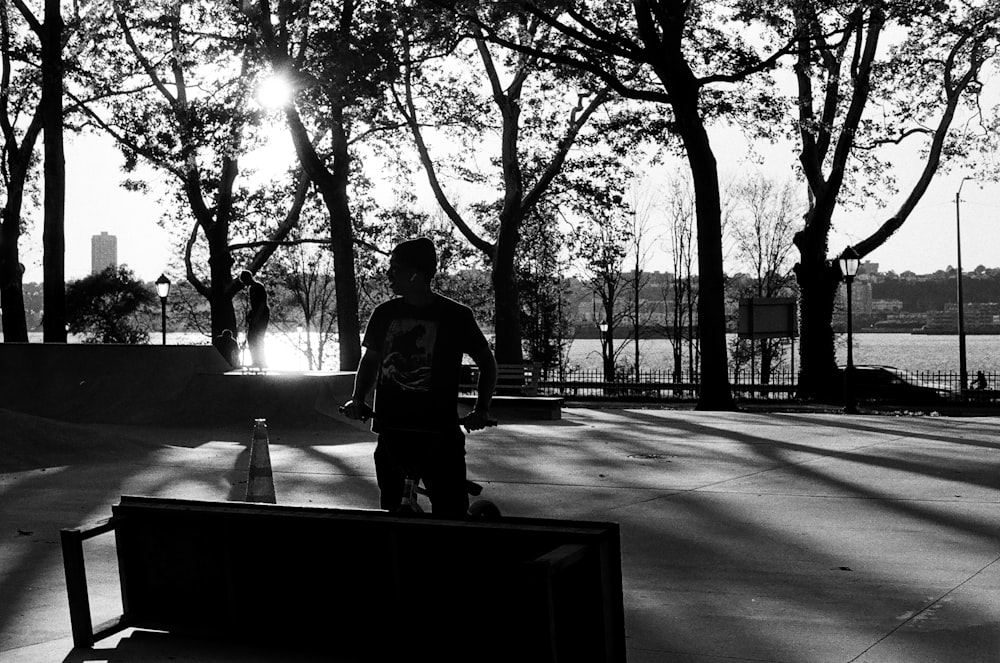 a man standing next to a park bench