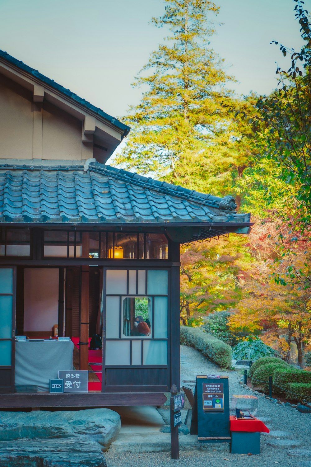 a small building with a blue roof and a sign in front of it