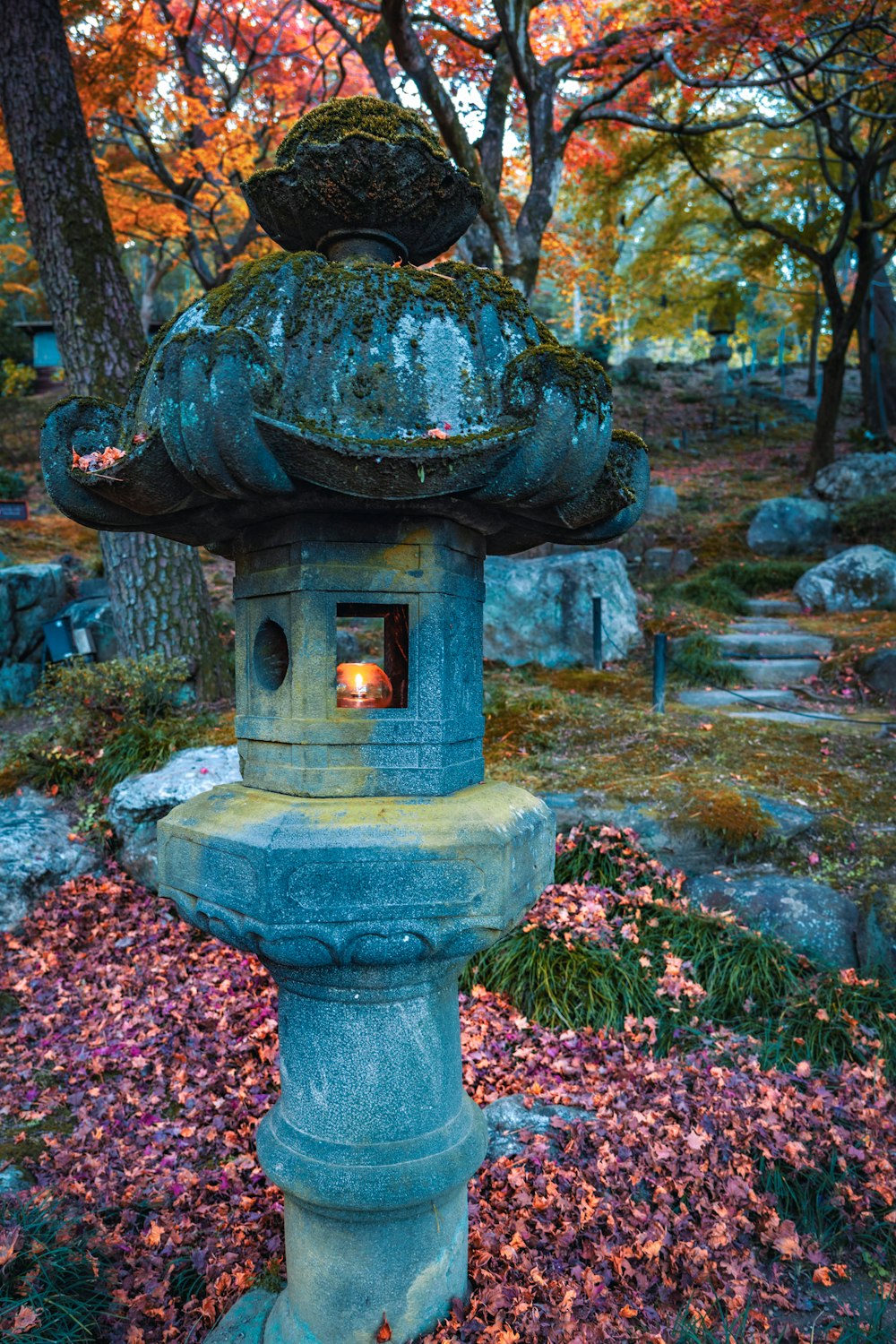 a stone lantern in the middle of a garden