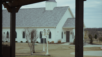 a white church with a clock tower in front of it