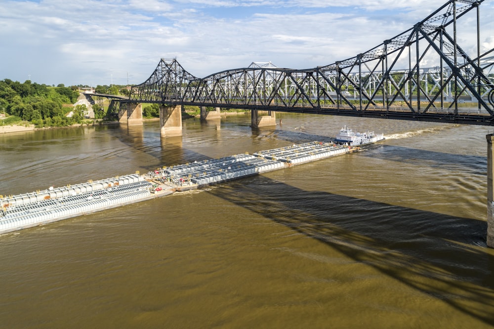 a large barge traveling down a river under a bridge