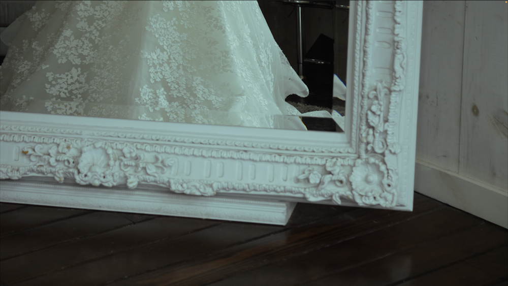 a wedding dress is reflected in a mirror
