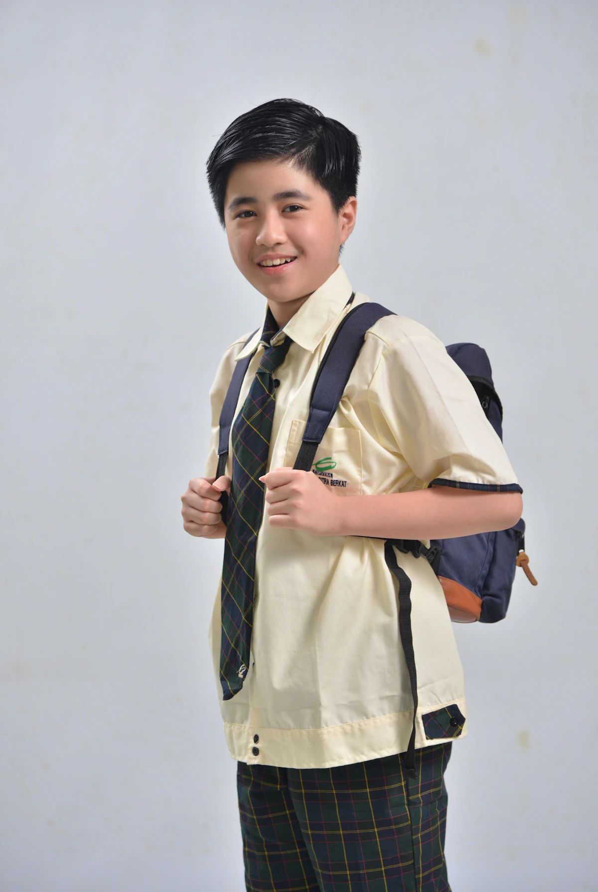 Seorang anak berseragam sekolah menyandang ransel