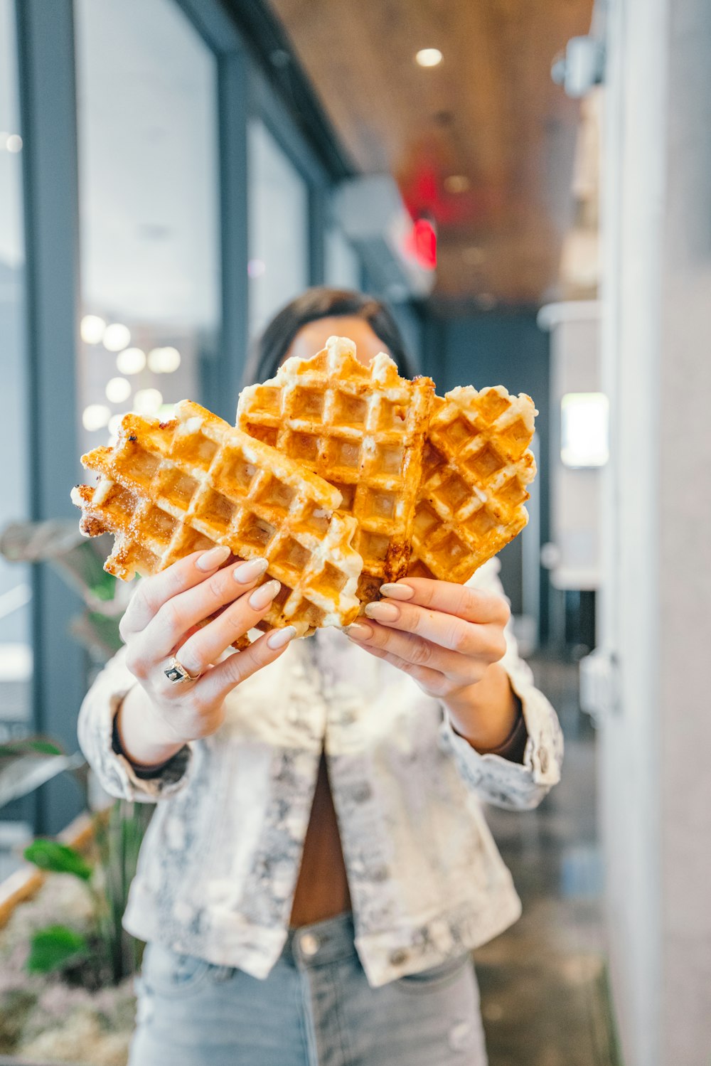 a woman holding a waffle in her hands