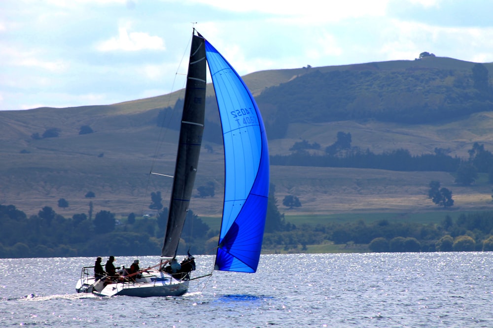 a sailboat with a blue sail is in the water