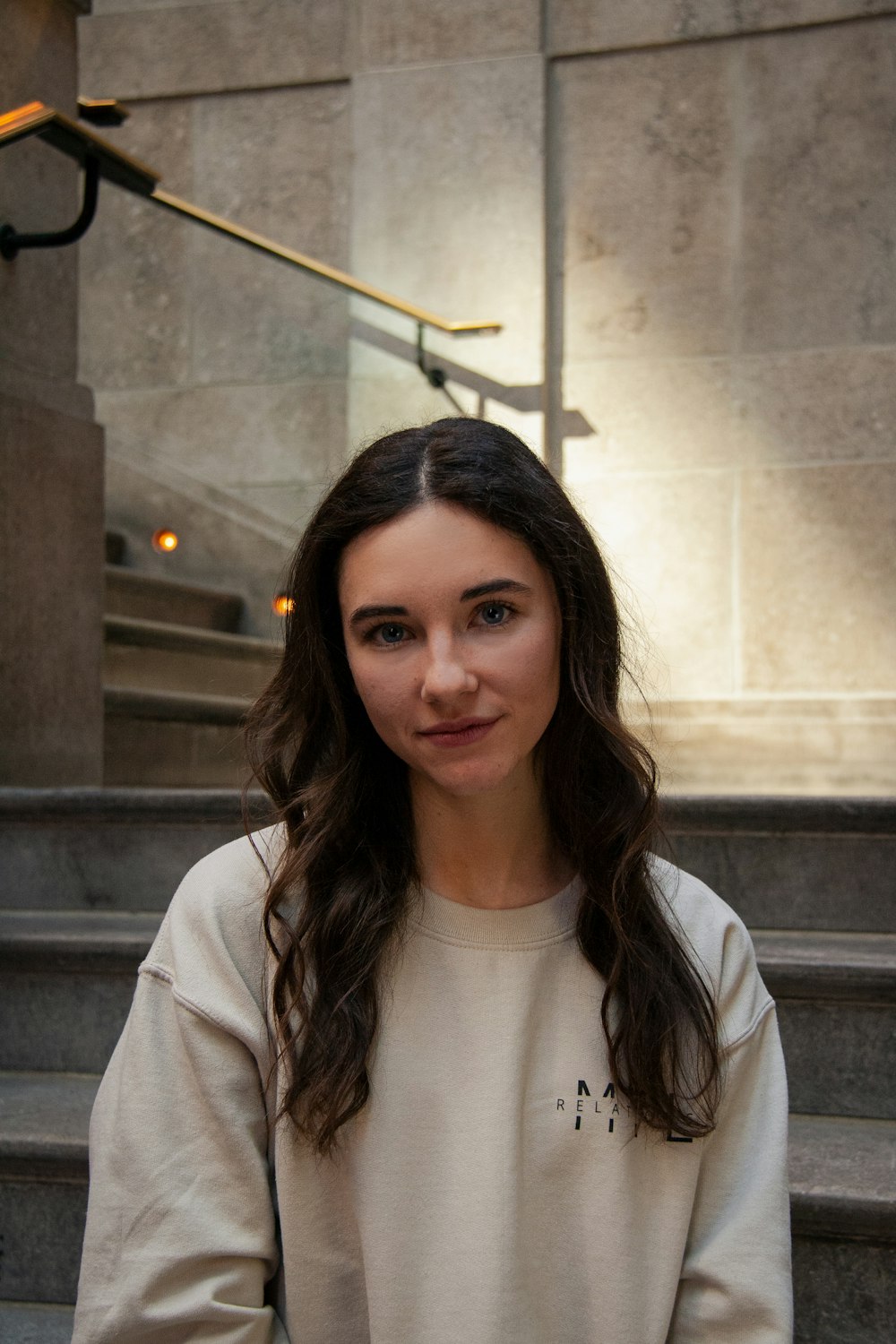 a woman standing in front of a set of stairs