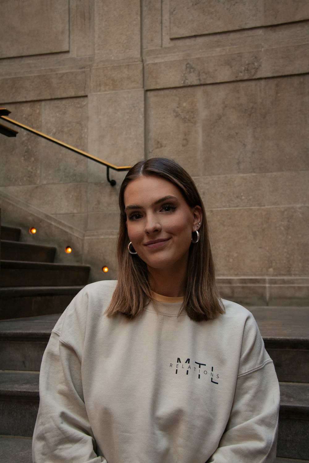 a woman standing in front of some stairs