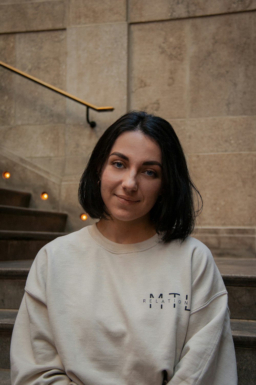 a woman standing in front of some stairs