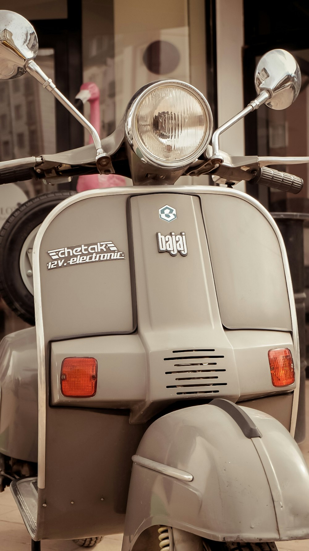 a grey scooter parked in front of a building