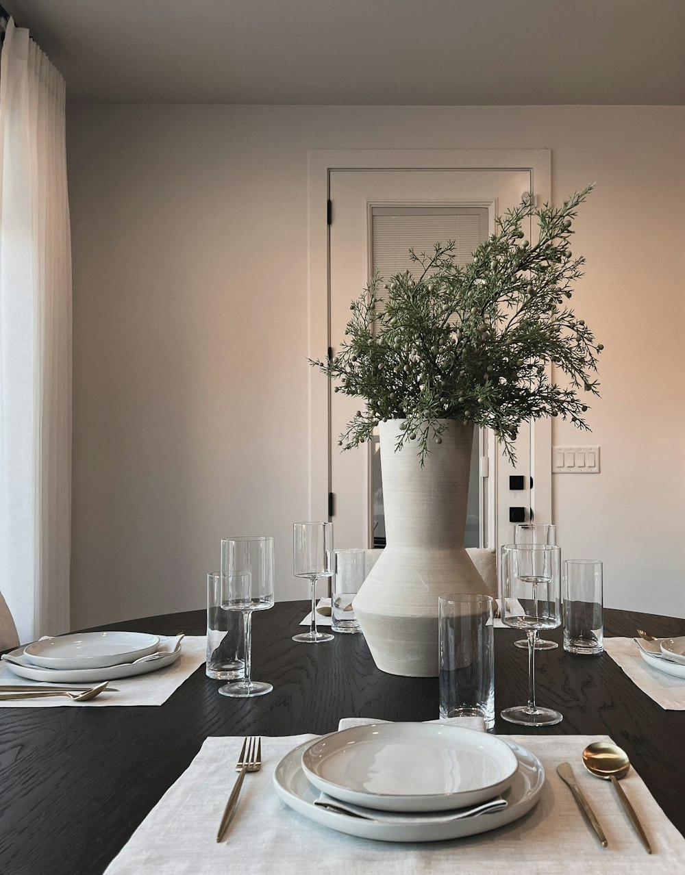 a dining table with a vase of flowers on top of it