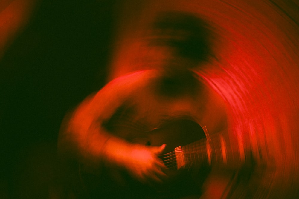 Una foto borrosa de una persona tocando una guitarra