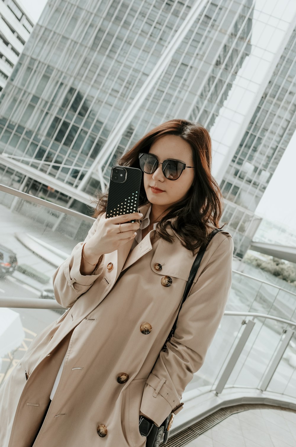 A woman in a trench coat holding a cell phone photo – Free Portrait  photography Image on Unsplash