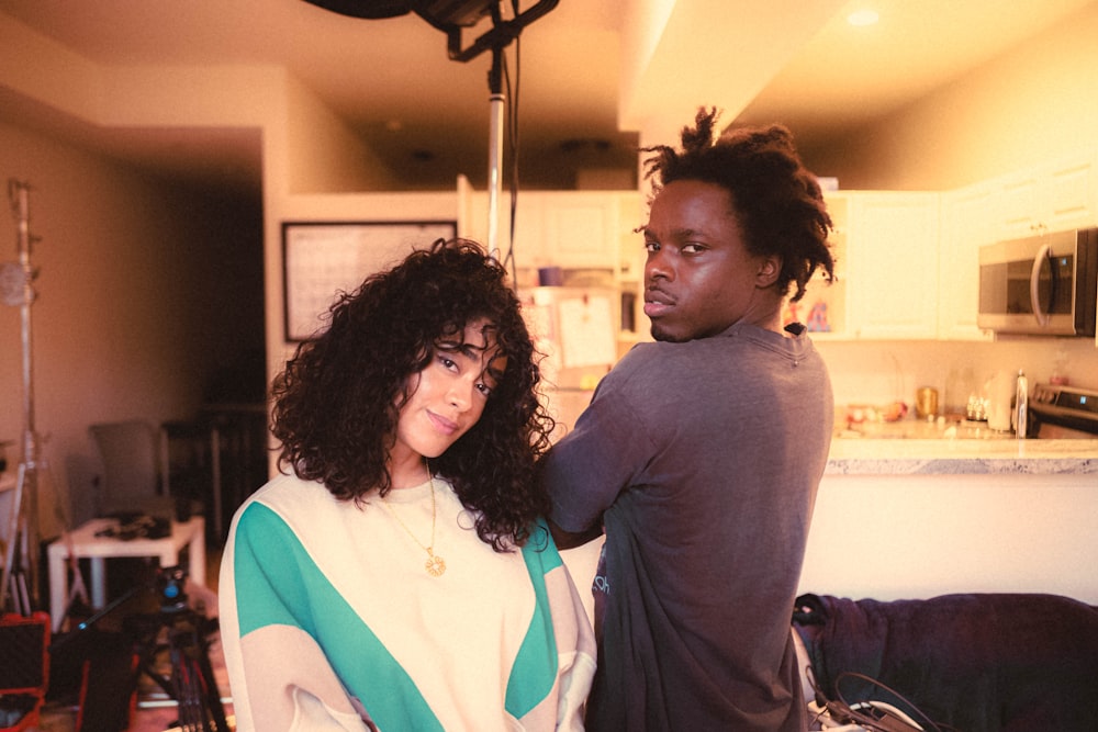 a woman standing next to a man in a kitchen