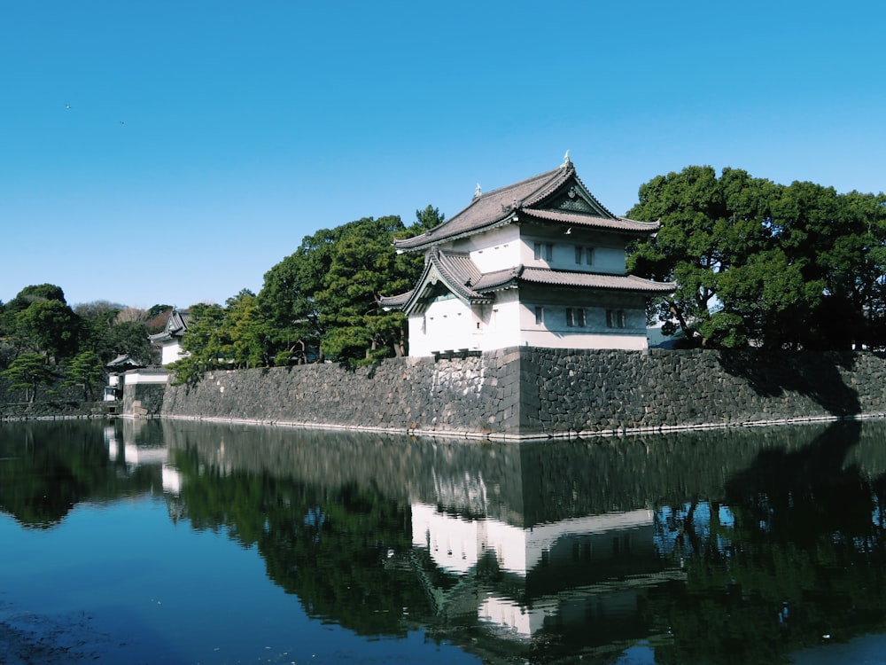 a building sitting on top of a lake next to a forest