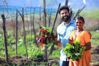 a man and a woman holding flowers in a field
