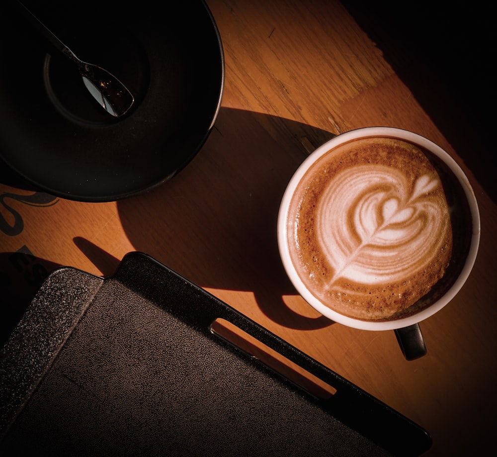 a cappuccino on a table with a spoon next to it