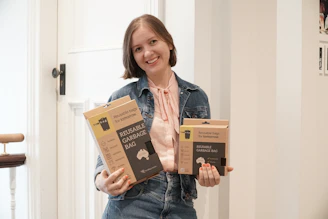 a woman holding three boxes of organic dog food