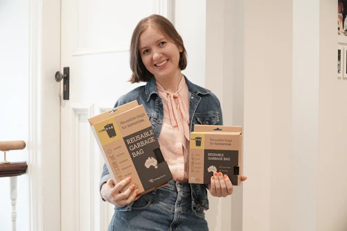a woman holding three boxes of organic dog food