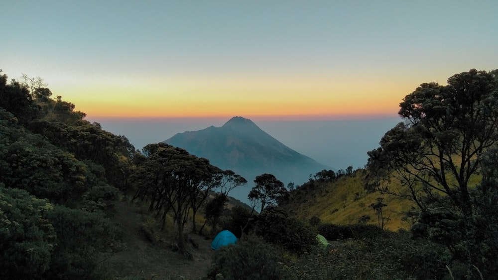 a view of a mountain with a tent in the foreground