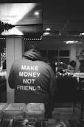 a man wearing a jacket that says make money not friends