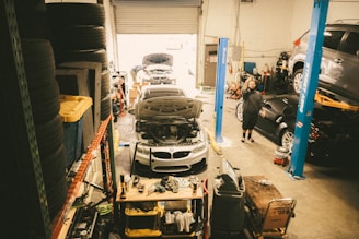 a car in a garage being worked on by a mechanic