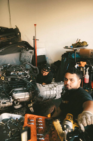 two men working on a car in a garage