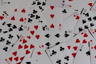 a pile of playing cards with hearts and spades