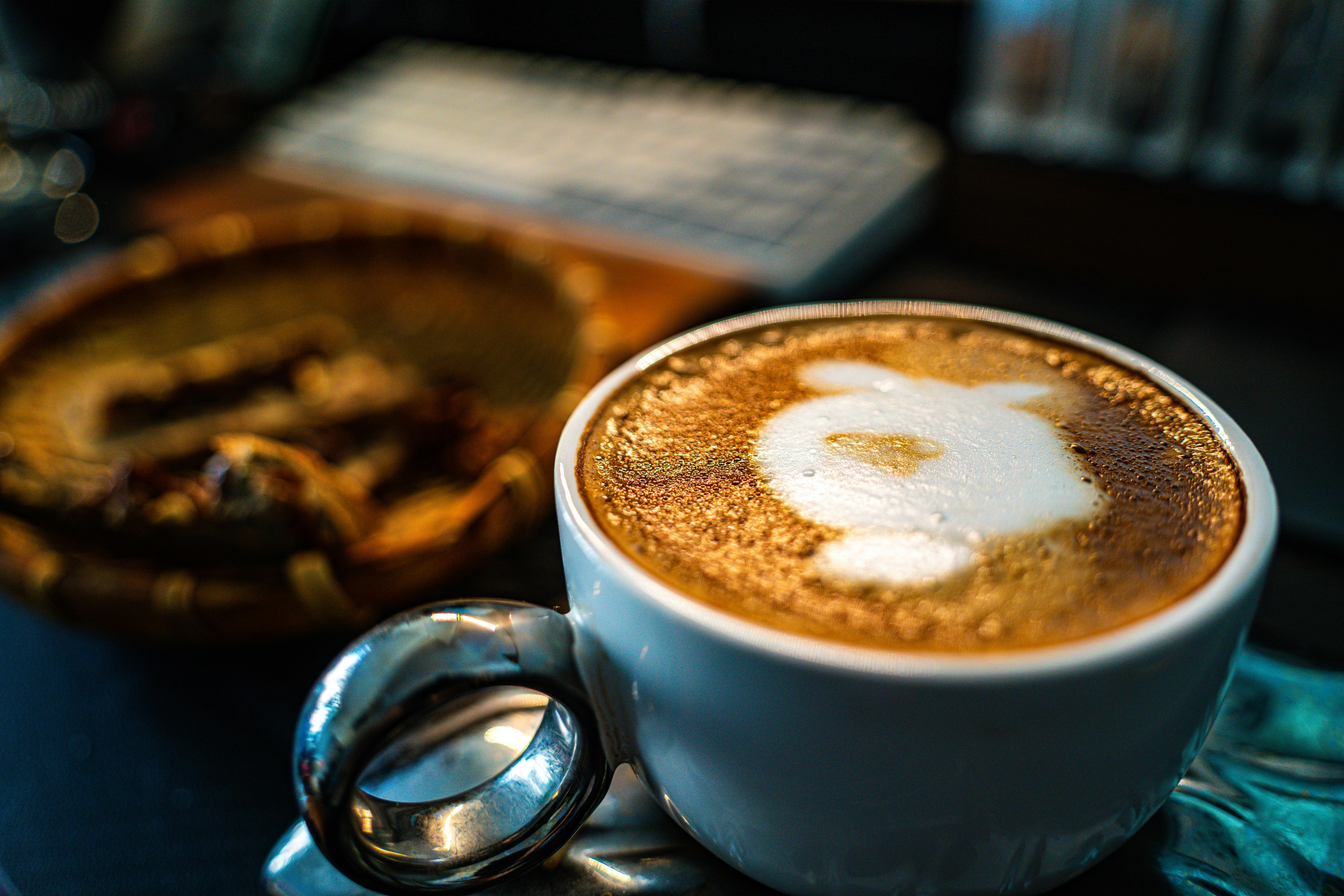 a cup of cappuccino with a spoon on a table