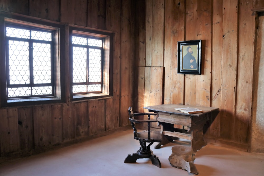 a room with wood paneling and a desk with a chair