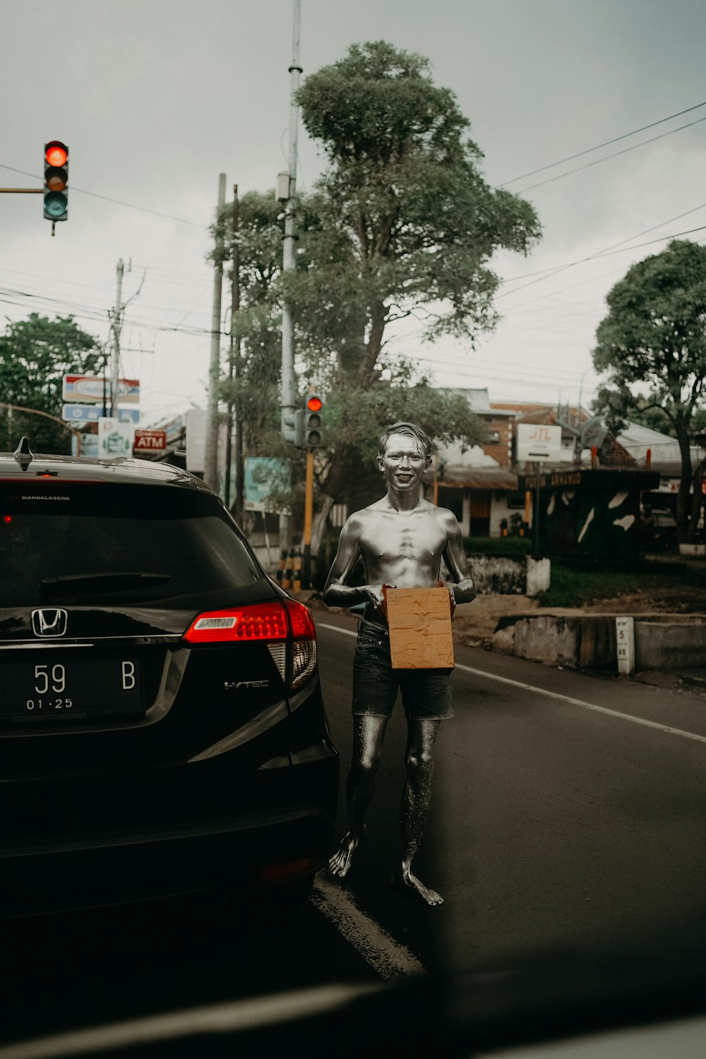 une statue d’un homme debout à côté d’une voiture