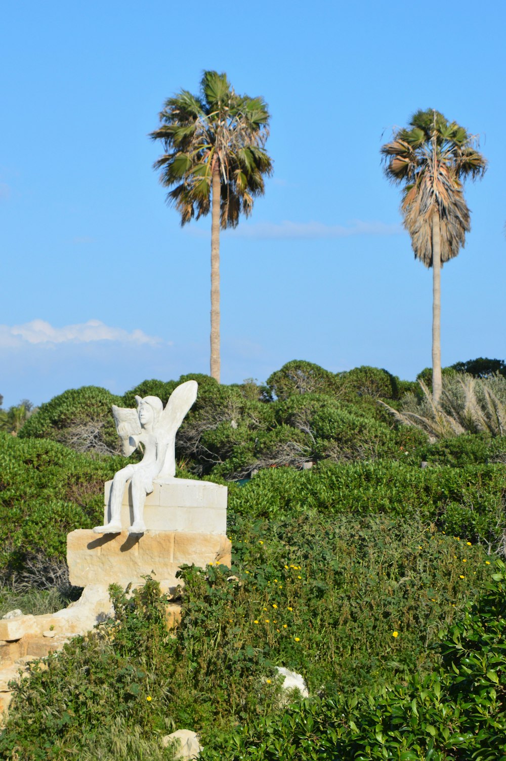 a statue of an angel sitting on a bench