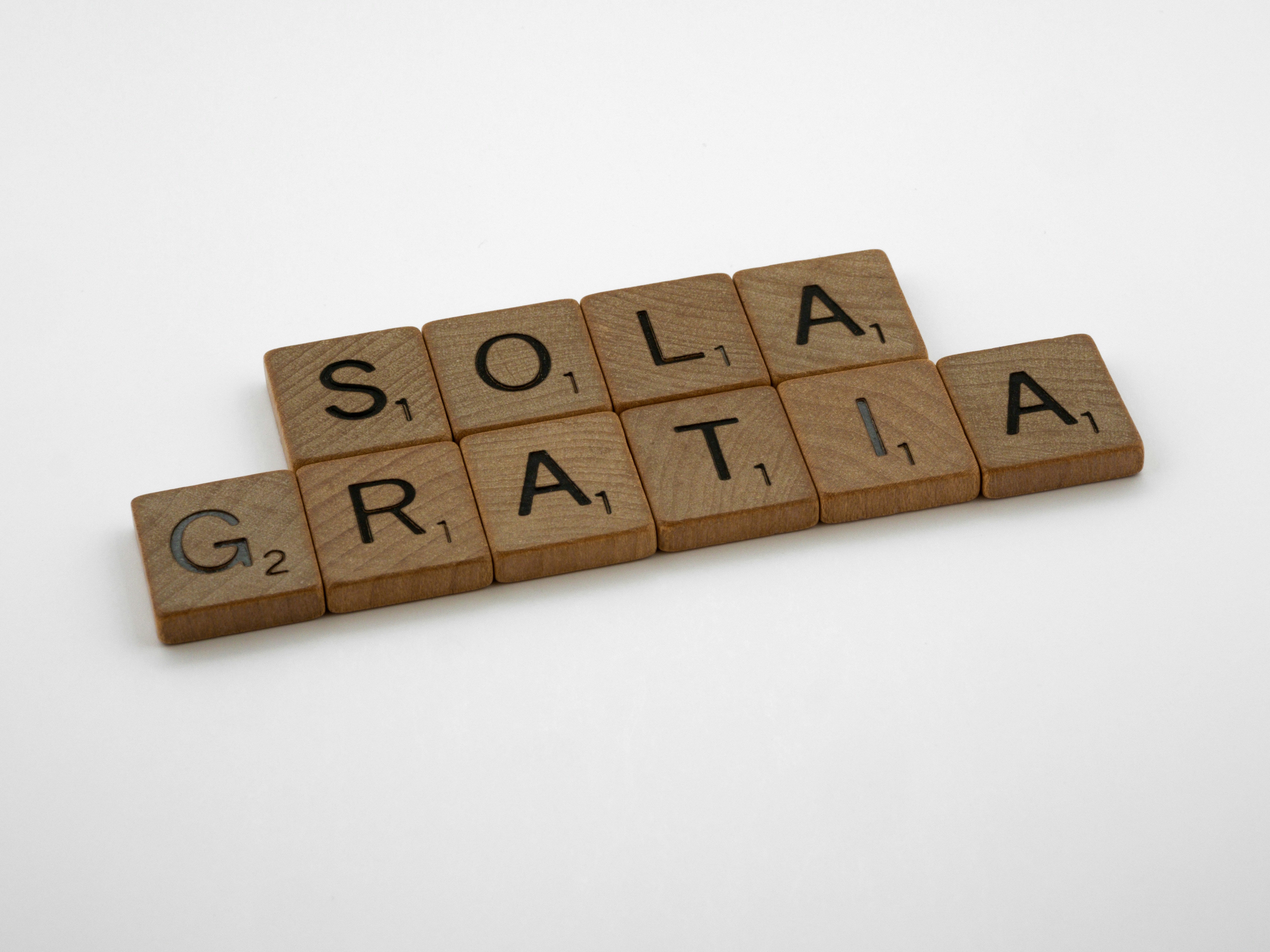 a scrabbled wooden block spelling out the word solar gratia
